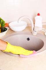 Male hand in gloves with sponge washing washbasin