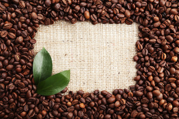 Coffee beans with leaves on burlap sack