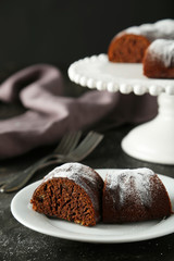 Chocolate bundt cake on plate on black background