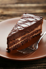Dark chocolate cake on brown wooden background