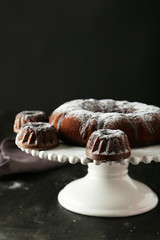 Chocolate bundt cakes on cake stand on black background