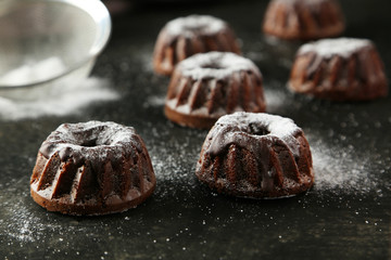 Chocolate bundt cakes with icing sugar on black background