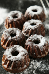 Chocolate bundt cakes with icing sugar on black background
