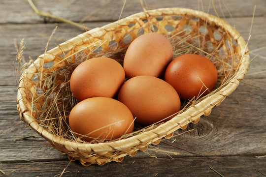 Eggs in basket on grey wooden background
