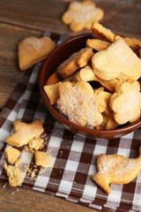 Cookies in bowl on brown wooden background