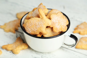 Cookies in a cup on white wooden background