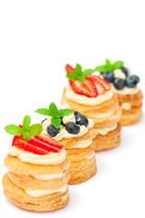 homemade puff pastry stuffed with cream and berries on white
