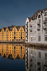 Obraz premium Jugend buildings in Alesund, Norway, reflected in beautiful calm sea. Vertical.