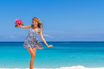 young happy girl with flower bouquet on tropical sea and beach b