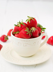 strawberries in ceramic cup on a white background