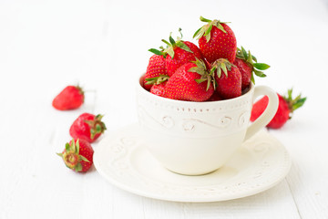 strawberries in ceramic cup on a white background