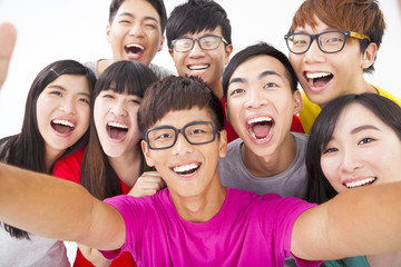 group of smiling friends with camera  taking self photo