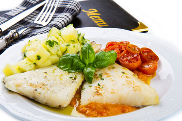 white dish of Fresh black cod with potatoes and tomatoes sauce