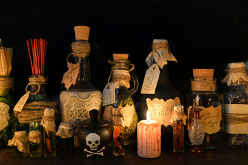 Halloween still life with witch bottles and bloody candle