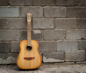 Fototapeta na wymiar Old Abandoned Guitar and Brick Wall