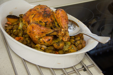 chicken baked with spices vegetables on a white porcelain dish