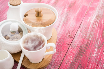 Tea cups with teapot on old wooden table