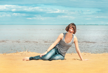 Fototapeta na wymiar Happy woman sitting on the beach