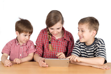 Happy Siblings Sitting at the Desk and Using Tablet Isolated