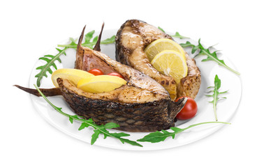 Grilled carp steaks with lemon and tomatoes.