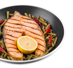 Frying pan with salmon steak.