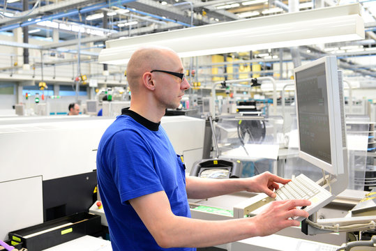Ingenieur in Fabrik steuert Maschine in der HiTech Fertigung