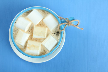 A cup of hot chocolate with marshmallows on the wooden background