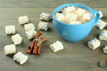A cup of hot chocolate with marshmallows on the wooden background