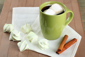 A cup of hot chocolate with marshmallows on the wooden background