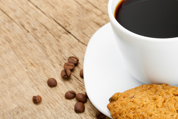 Cup of black coffee with cookies on old wooden table