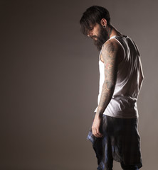 a young man with a beard and tattoos in a white shirt