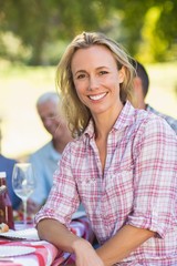 Pretty blonde woman smiling at camera during a picnic