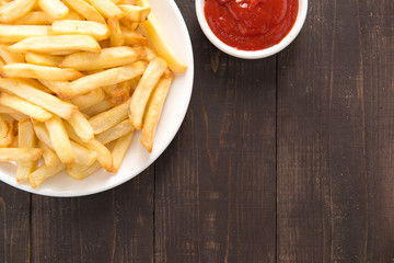 French fries with ketchup on wooden background