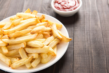 French fries with ketchup on wooden background
