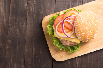 Top view BBQ hamburgers on cutting board on wooden background.