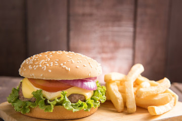 BBQ hamburgers with french fries on wooden background.
