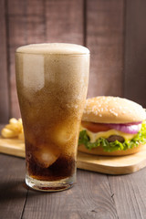 Cola with BBQ hamburgers on wooden background.