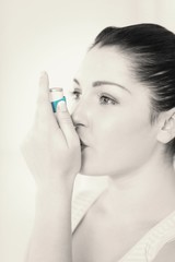 Fototapeta premium Woman with asthma using an asthma inhaler