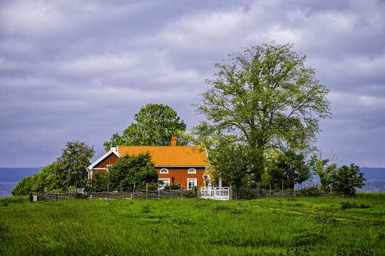 Ett r&ouml;tt hus vid sj&ouml;n