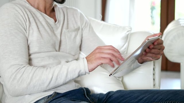 Man using a digital tablet in his apartment