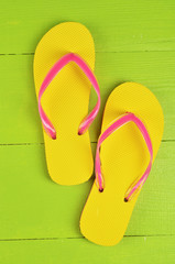 Flip Flops Yellow on green wooden background