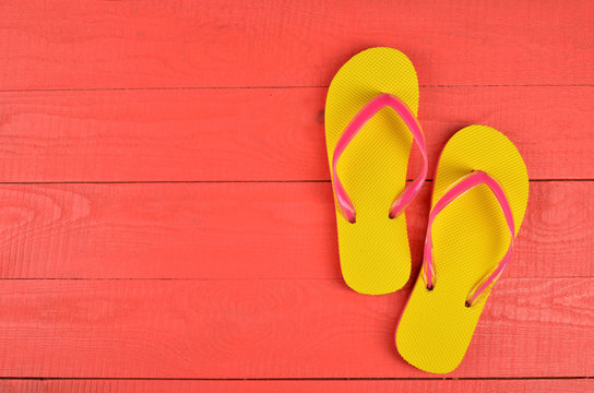 Flip Flops Yellow on red wooden background