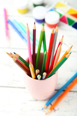 Fototapeta premium Colorful pencils in cup on white wooden background