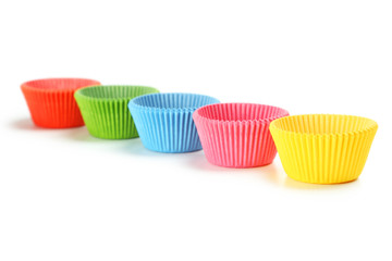 Empty colorful cupcake cases isolated on white