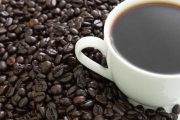 Fototapeta premium Coffee cup with beans on wood table