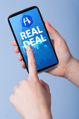 Man presses a touch screen smart phone with the symbol of an rea