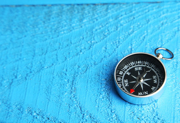 Compass on blue wooden background