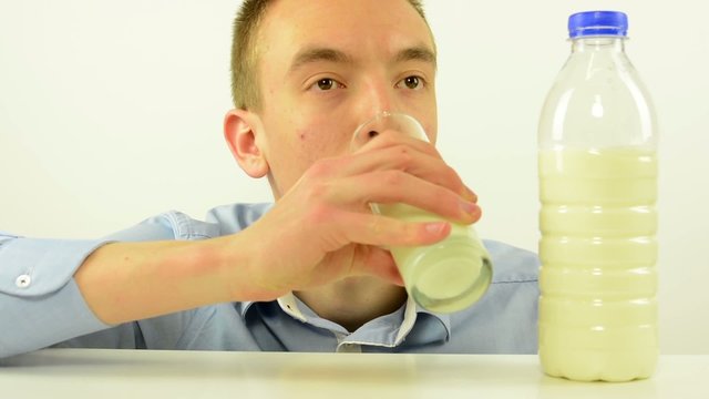 young man drinks milk - white background studio
