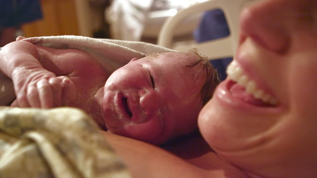 A newborn baby born just minutes before on her mothers chest