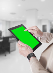 Mani e tablet con sfondo verde in uffici